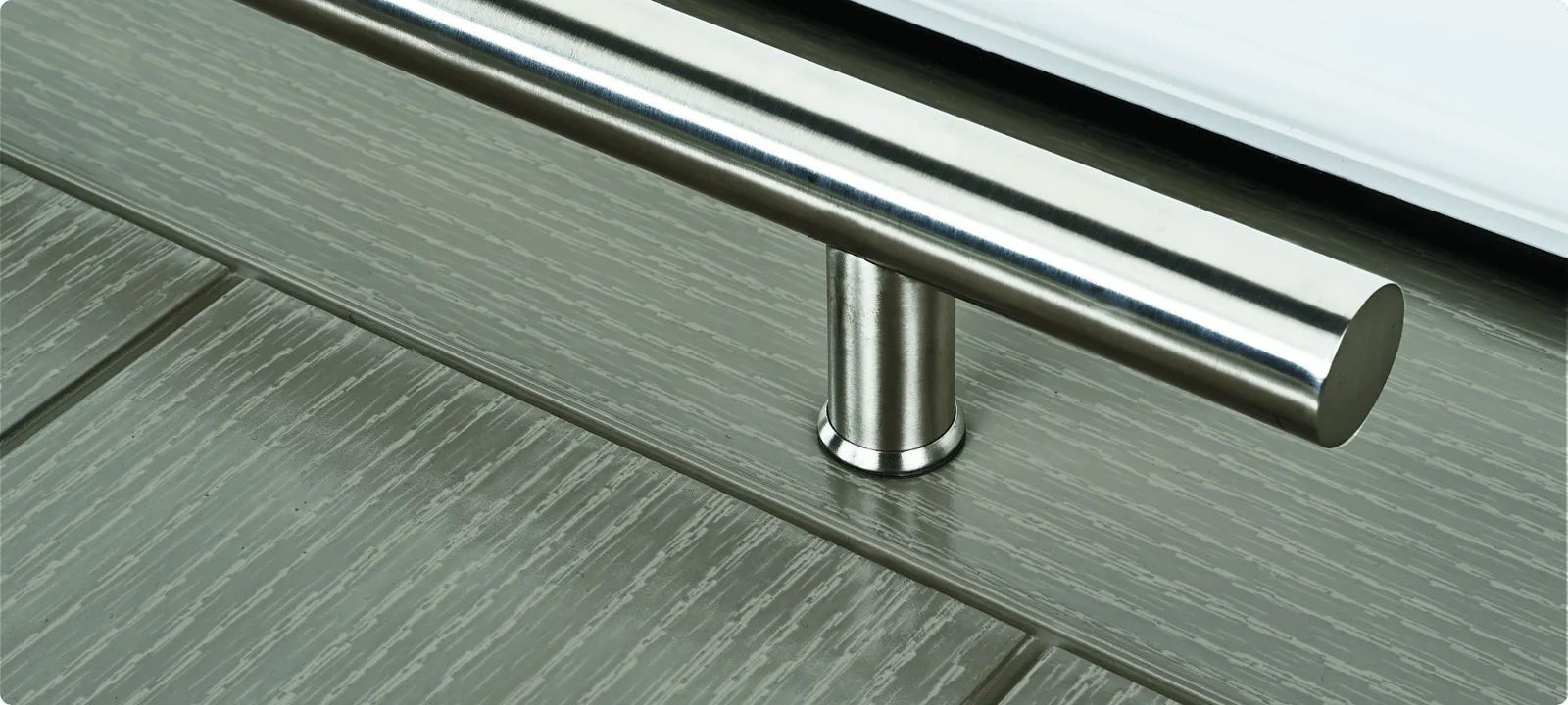 Brushed stainless steel bar handle on a light grey woodgrain composite door