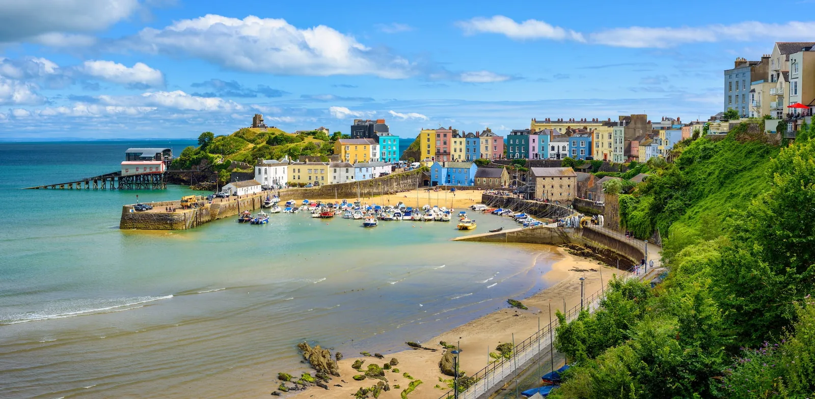 Colourful seaside houses above a harbour, with small boats on the water